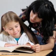 girl reading with help from woman