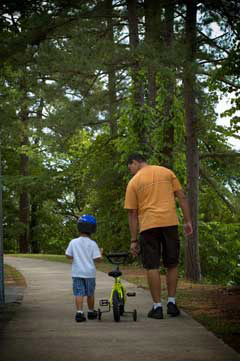 man walking with boy and boy's bicycle