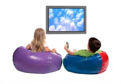 boy and girl watching television while sitting in beanbag chairs