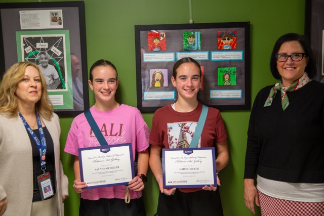 Children pose with their artwork.