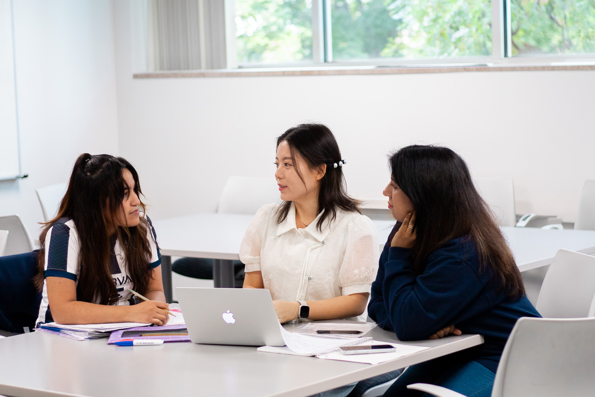 Students talking around a computer