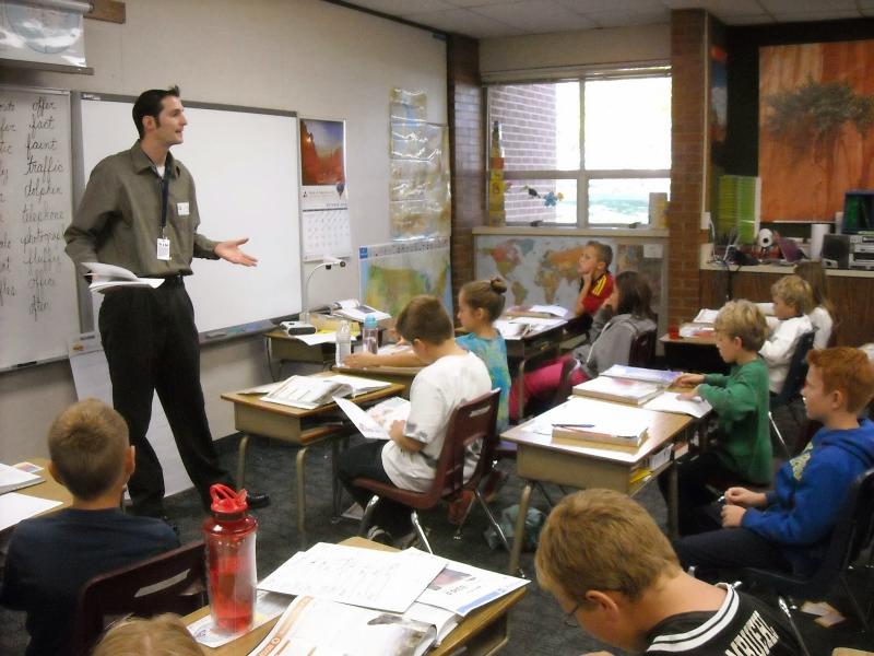 man instructs class of young students