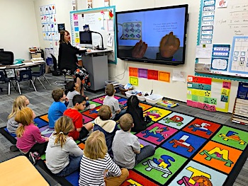 Class on carpet reading book