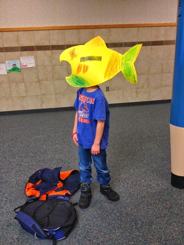 boy wearing paper fish hat