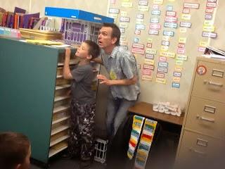 man and boy pretending to hide behind a shelf cabinet