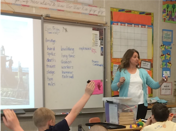 Teacher with students raising hands