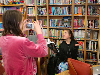 Student taking picture of another student posing