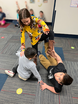 Students making a shape with their bodies