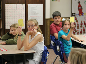 Students holding up letters