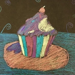 Rainbow cupcake on orange plate.