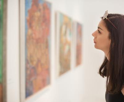 girl looking at paintings