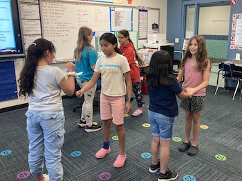 Three pairs of students creating and practicing handshakes