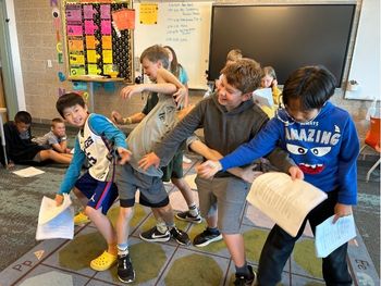 Students making different shapes to add to a story in the Martha game