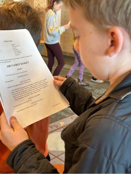 Student holding their script of "Amy's First Basket"