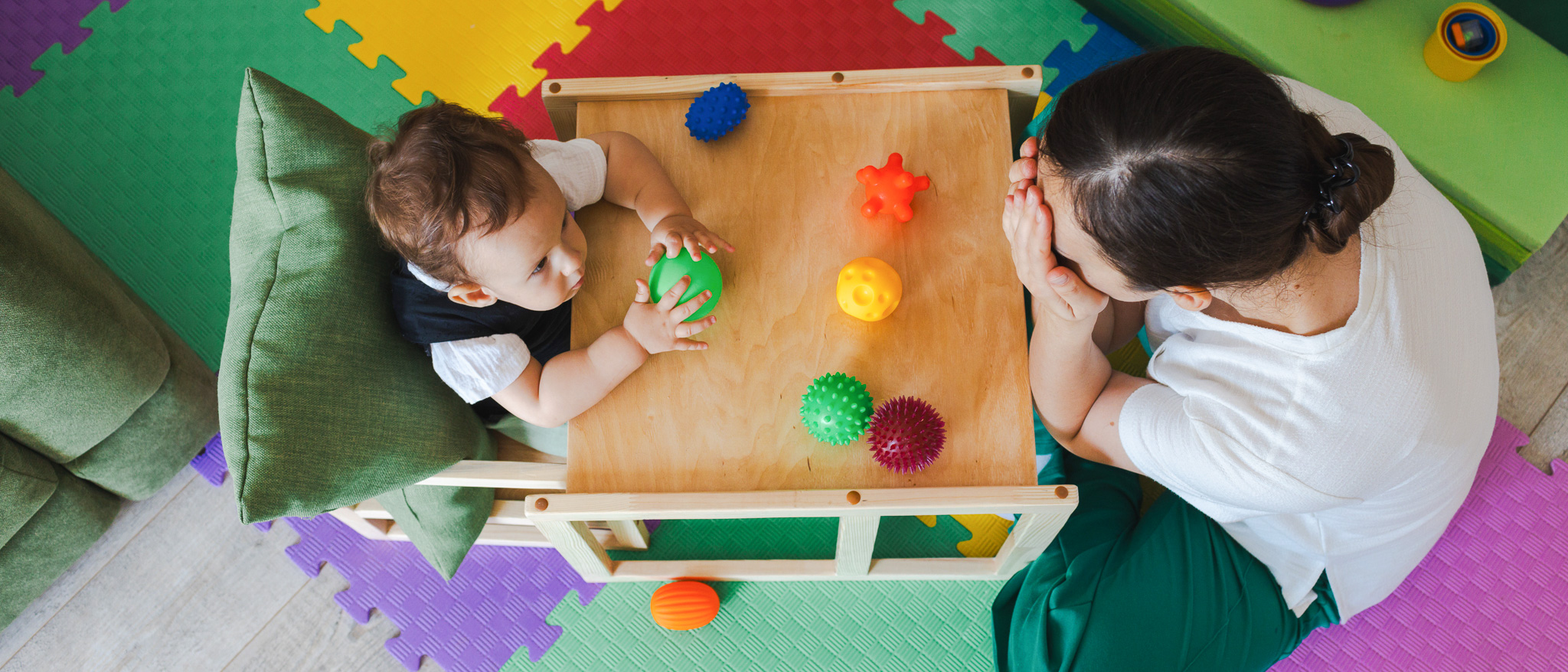 Woman and toddler play with toys and play peekaboo