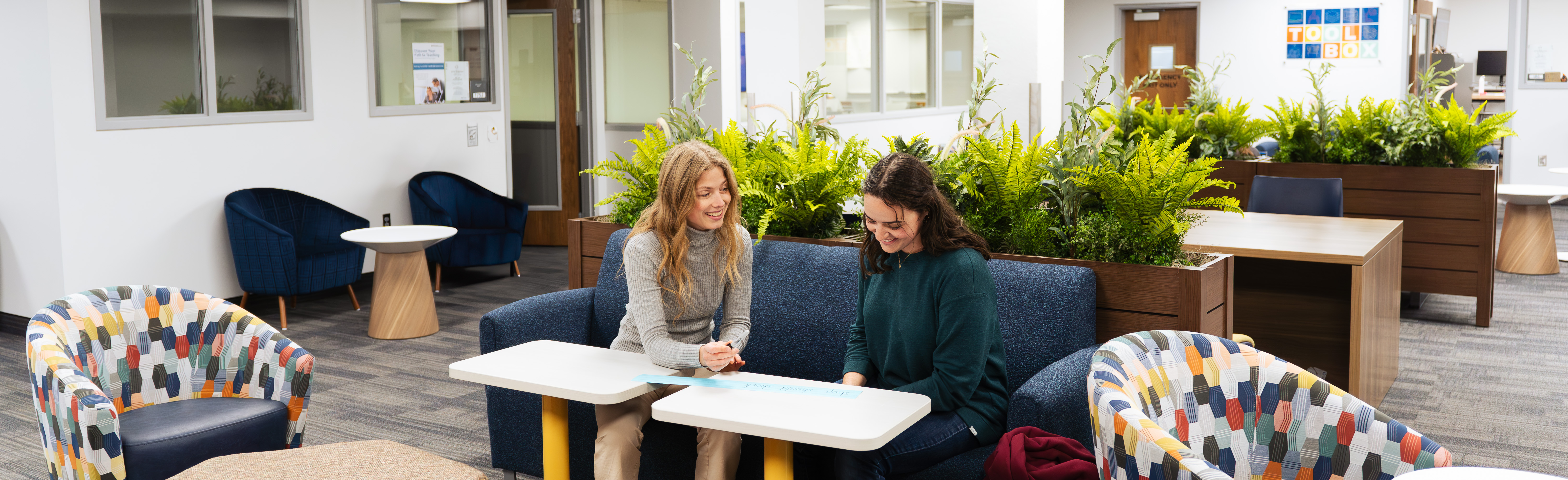 Two students sitting at a table talking together.