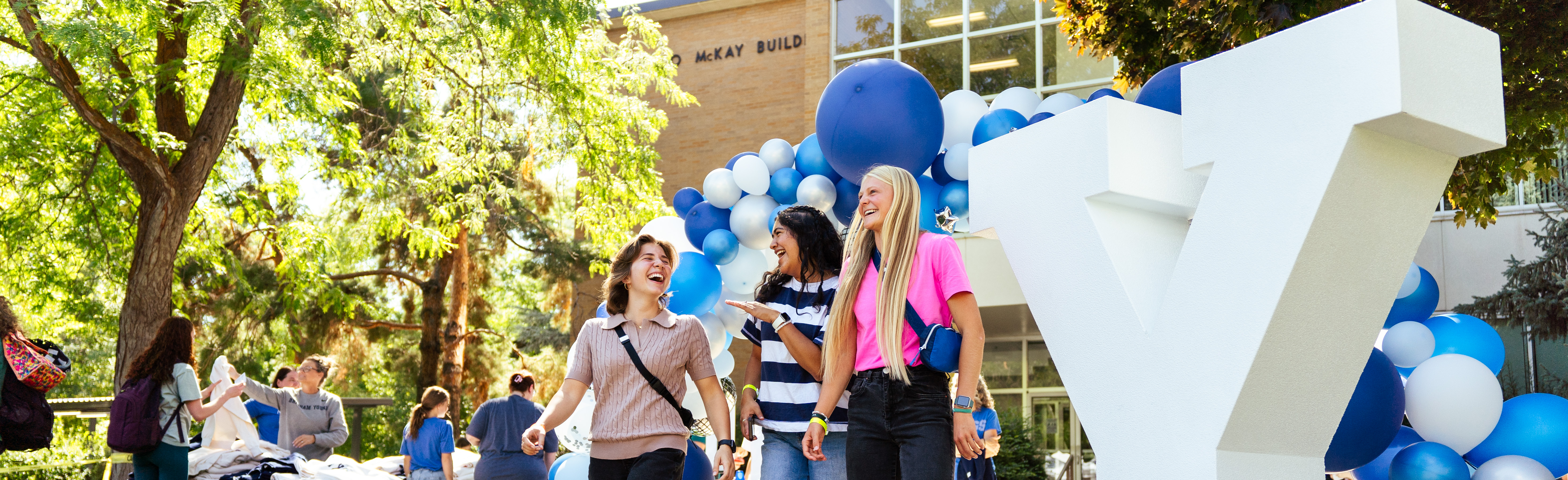 A group of students talking at an event near the McKay School building