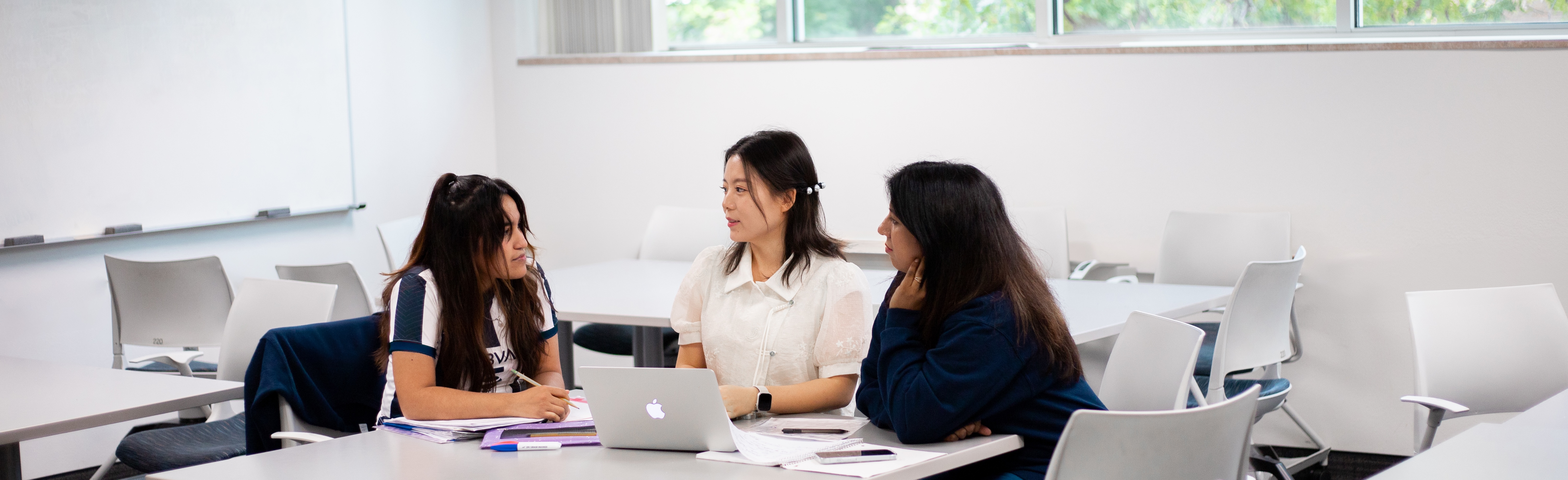 Students talking around a computer