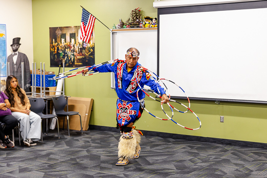 man doing traditional native american 'entertaining dance' with multiple hoops