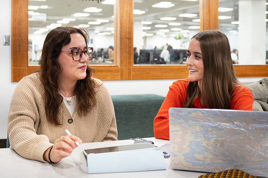 two girls looking at each other at a desk