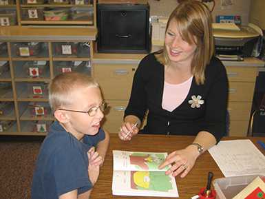 boy reading with help from woman