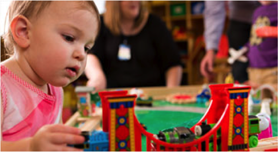 girl playing with toy train