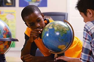 boy studying a globe