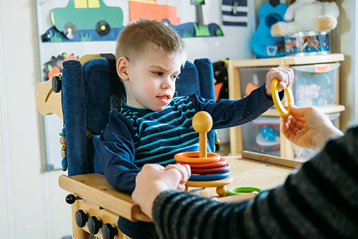 a young boy with cerebral palsy plays with toys