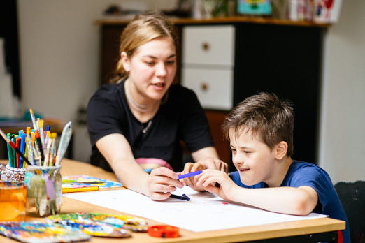 Woman helping child color