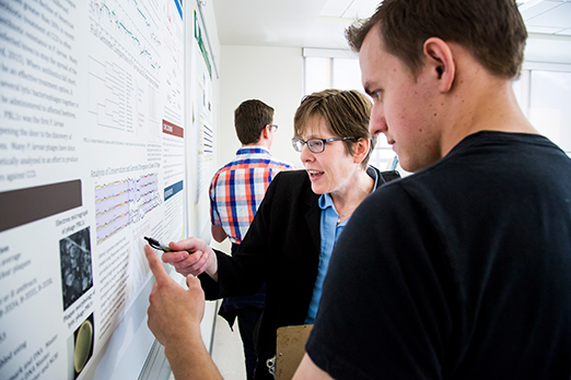 a teacher writes on the whiteboard with a student