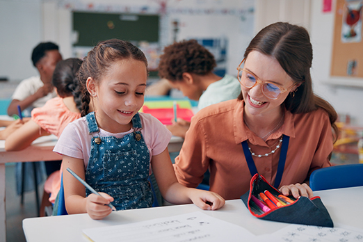 a young teacher smiles as she listens to a student speak
