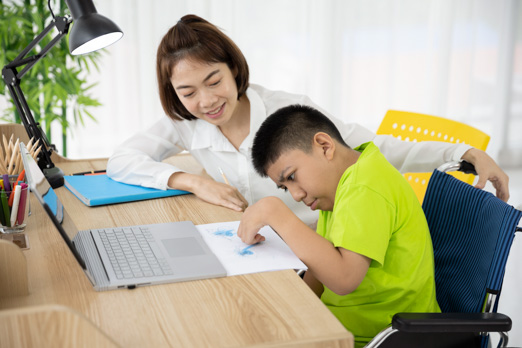 Woman helping child on laptop