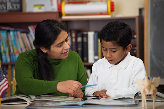 a teacher works with a student learning to read