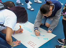 Girls writing on a poster