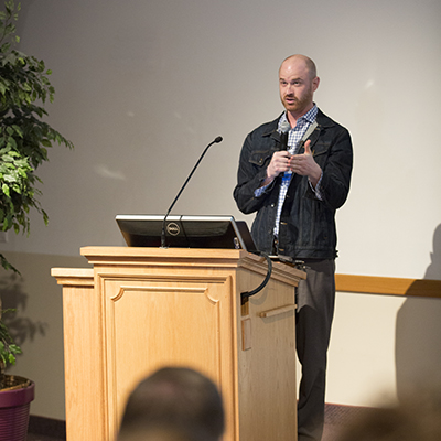 a man standing while giving a presentation