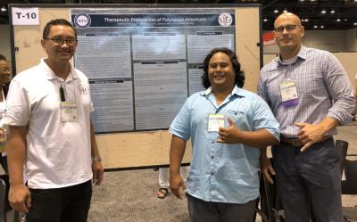 three men standing near a research poster