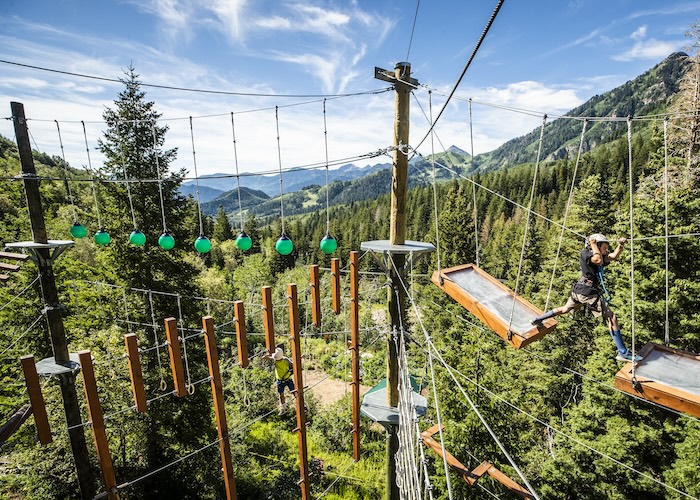 Young girl doing ropes course hight in the mountains