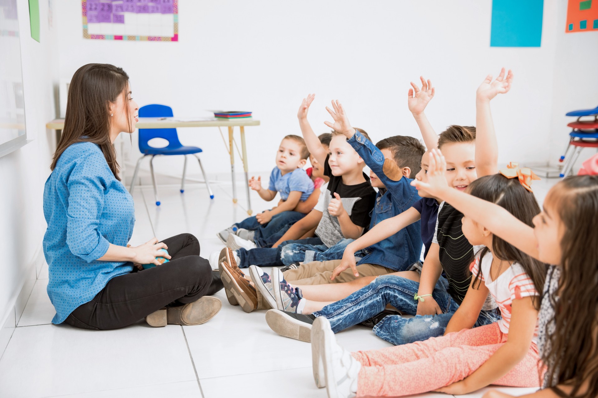 A preschool teacher with a group of students