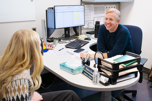 Woman talking to man at desk