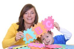 woman holding letter blocks toy with boy