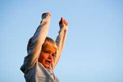 boy celebrating with arms raised above head