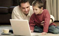 man and boy looking at laptop computer