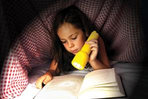 girl reading with flashlight