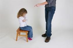 angry girl sitting in chair while being lectured by adult