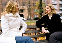 two women talking on a park bench