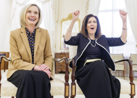 Sister Cordon laughing with Sister Craig holding her hands up in celebration