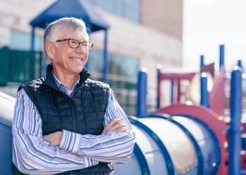 Portrait of Gary Seastrand in front of a playground set with the JFSB in the background.