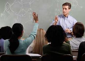 Male teacher standing in front of chalk board