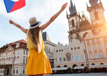 girl standing in public square holding czech flag