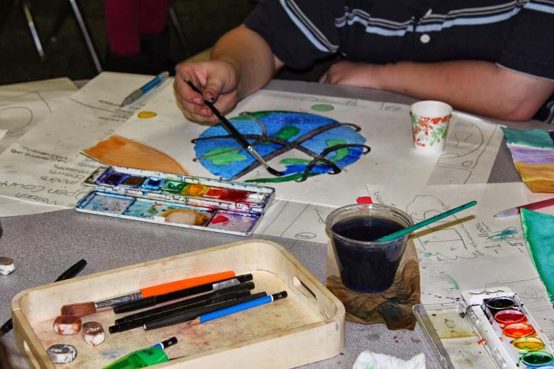 boy painting a planet with watercolor